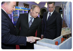 Astrakhan Governor Alexander Zhilkin showing an exhibition of urban achievements in the region and state support for small and medium-sized companies to Prime Minister Vladimir Putin