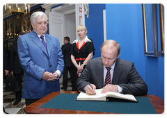 Prime Minister Vladimir Putin leaves a message in the guestbook at the Moscow State Picture Gallery of Ilya Glazunov
