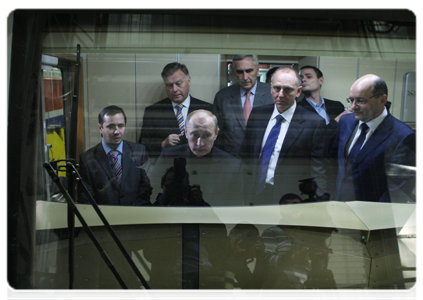 Prime Minister Vladimir Putin examining the cab of the new electric freight locomotive 2ES10 as experts explain how it operates