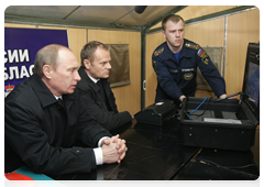Russian Prime Minister Vladimir Putin holding a conference call with Polish Prime Minister Donald Tusk at the Tu-154 crash site