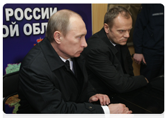 Russian Prime Minister Vladimir Putin holding a conference call with Polish Prime Minister Donald Tusk at the Tu-154 crash site