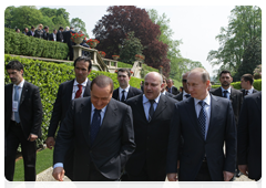 Prime Minister Vladimir Putin and Italian Prime Minister Silvio Berlusconi, left, foreground, visiting the park at Villa Gernetto after the press conference