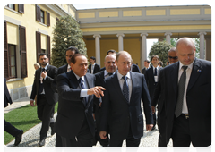 Prime Minister Vladimir Putin and Italian Prime Minister Silvio Berlusconi, left, foreground, visiting the park at Villa Gernetto after the press conference