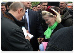 Before leaving the memorial, Prime Minister Vladimir Putin gave a few autographs to locals