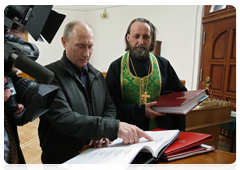 Prime Minister Vladimir Putin visiting the Church of Theotokos: Salvation of the Perished to see the book listing the names of the thousands of soldiers who defended Nevsky Pyatachok. Mr Putin found the name of his father in the book