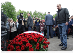 Prime Minister Vladimir Putin and the father visiting a monument at the War Mass Grave memorial