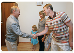 Vladimir Putin speaking to a family in one of the new low-rise residential development in Kotelnikovo after visiting the Gremyachin potassium salt deposits
