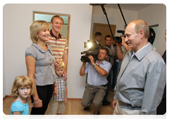 Vladimir Putin speaking to a family in one of the new low-rise residential development in Kotelnikovo after visiting the Gremyachin potassium salt deposits