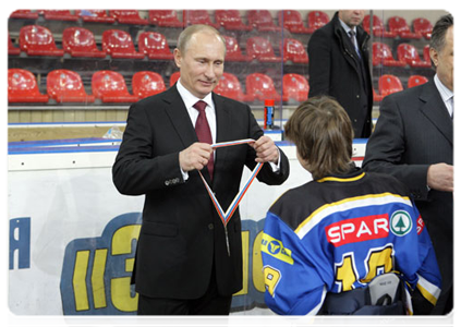 Prime Minister Vladimir Putin hands the Golden Puck Youth Hockey Cup to the Chelyabinsk White Bears after the game