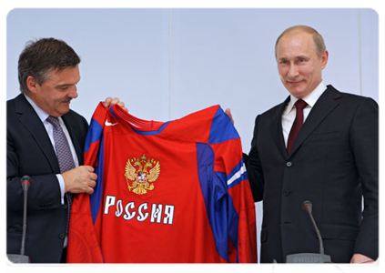 Rene Fasel, president of the International Ice Hockey Federation, making Prime Minister Vladimir Putin the gift of a hockey uniform after the news conference in Bratislava