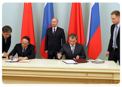Deputy Prime Minister Igor Sechin and Chinese Vice-Premier Wang Qishan signing a protocol to the memorandum of understanding on natural gas partnership in the presence of Prime Minister Vladimir Putin