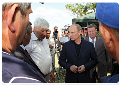 Prime Minister Vladimir Putin visits a cooperative farm and talks with its workers