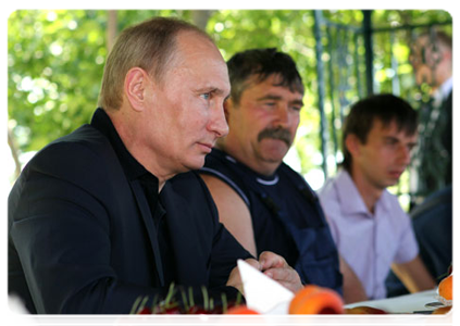 Prime Minister Vladimir Putin visits a cooperative farm and talks with its workers