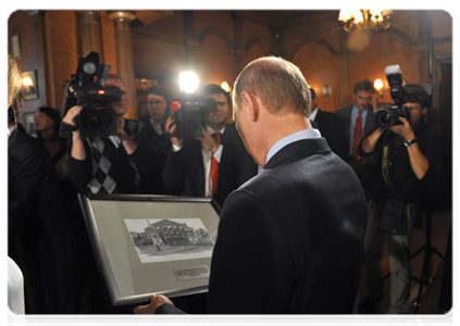 В подарок от творческого коллектива Государственного театра наций В.В.Путину вручили гравюру с изображением театра