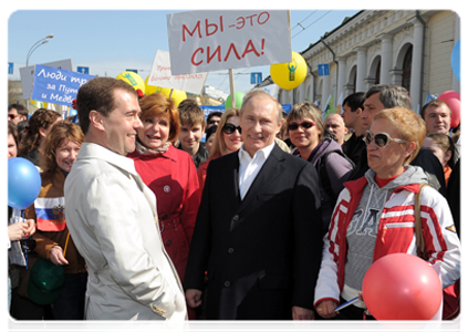 President Dmitry Medvedev and Prime Minister Vladimir Putin participate in a May Day parade