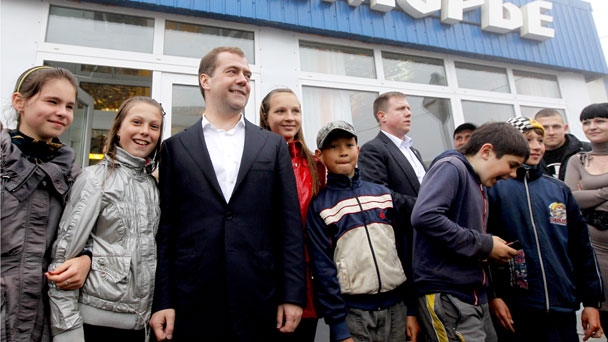 Prime Minister Dmitry Medvedev poses with children after visiting Primorye store